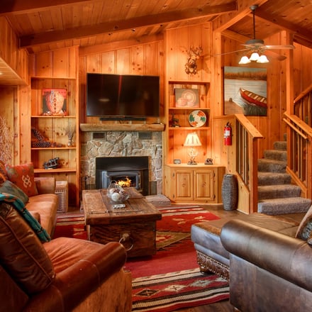 Willow Cove Lodge rustic living room with stone fireplace